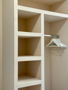 a white book shelf in a room at LIV Aspropyrgos in Asprópirgos