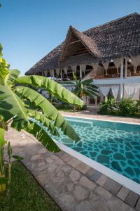 a resort with a swimming pool and a building at Mwezi - Maisha Resort in Watamu
