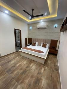 a bedroom with a large bed and a ceiling at Hotel Alpine Inn in Dera Bassi