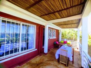 a porch with a table and some windows at Maison en bord de mer in Diego Suarez