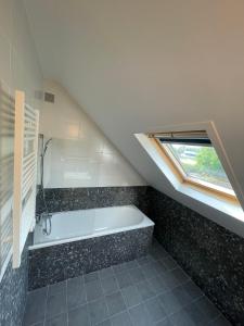 a bathroom with a bath tub and a window at Maison Cosy à Chartres in Chartres