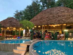 a group of people standing around a pool at a resort at Mật Retreat in Ba Vì