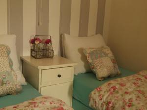 una camera con due letti e un comodino con fiori di Apartment Boven Jan 572 a Den Helder