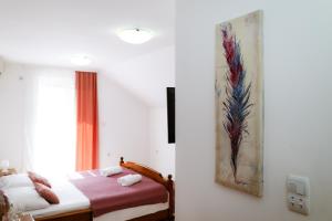 a bedroom with a bed and a painting on the wall at Apartments Ivana in Tivat