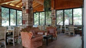 a dining room with chairs and tables and windows at Hotel Natali in Dhërmi
