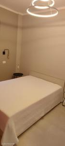 a white bed in a room with a light at La Panoramica in Varazze