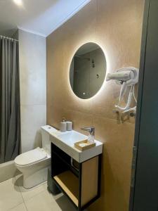 a bathroom with a sink and a toilet and a mirror at Buganvillas Studios in Preveza