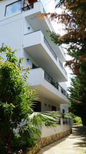 a white building with balconies on the side of it at Hotel Natali in Dhërmi