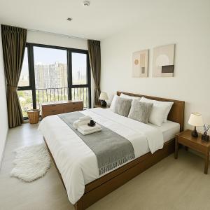 バンコクにある2BR 2BA Luxury Lifestyle 5min walk Thonglor BTSの大きなベッドと大きな窓のある寝室