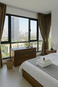 バンコクにある2BR 2BA Luxury Lifestyle 5min walk Thonglor BTSの大きなベッドと大きな窓のある寝室