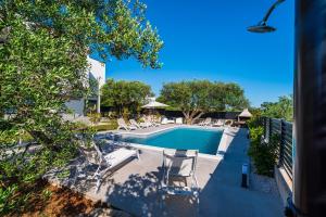 - une piscine avec des chaises longues à côté dans l'établissement Apartment Vista Mare 2 with heated pool, à Sveti Filip i Jakov