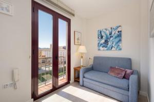 een woonkamer met een stoel en een raam bij OLD TOWN - Cultural Experience in Málaga +17 foto's