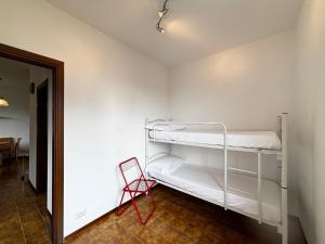 a room with two bunk beds and a red chair at Camellia Apartment Gravedona - Larihome A98 in Gravedona