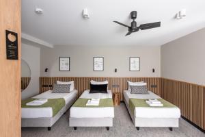 a room with two beds and a ceiling fan at AIRINN Vilnius Airport Hotel RENOVATED 2025 in Vilnius