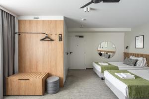 a hotel room with two beds and a mirror at AIRINN Vilnius Airport Hotel RENOVATED 2025 in Vilnius