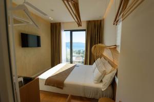 a hotel room with a bed and a large window at Mahoro Boutique Hotel in Vlorë +232 photos