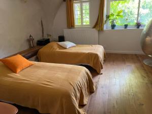 two beds in a room with a window and a room with two beds at La Genevraie in Gap