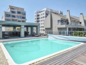 a large swimming pool in the middle of a building at Cape Town Beachfront Accommodation in Blouberg in Bloubergstrand +6 photos