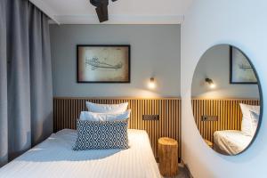 a small room with a bed and a mirror at AIRINN Vilnius Airport Hotel RENOVATED 2025 in Vilnius