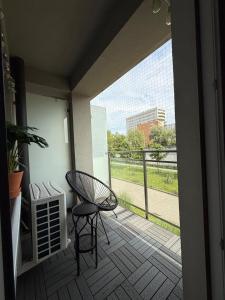 a balcony with a chair and a view of a building at VINCI apartment in Krakow