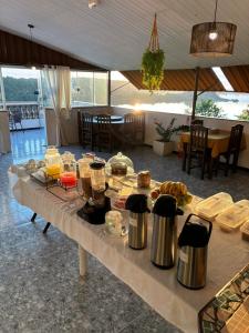 a long table with food and drinks on it at Pousada Costa do Sol in Maricá