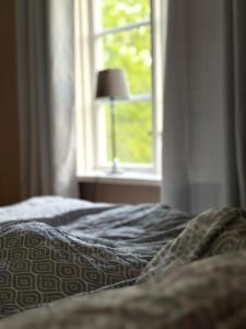 a bed in a bedroom with a window at Drängstugan - Tiny House in Johannesberg
