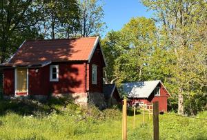 a red house in the middle of a field at Drängstugan - Tiny House in Johannesberg
