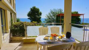 a table with a plate of food on a balcony at Апартаменти Бяла Бийч - Apartments Byala Beach in Byala