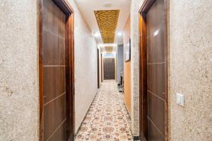 a corridor of a house with wooden doors and a tile floor at Super Hotel O The Signature Inn in Indirapuram