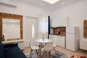 a living room with a table and chairs and a kitchen at Ambrelia Living in Shkodër