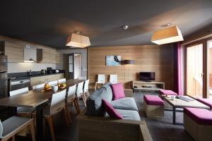 a living room with a couch and a table at CGH Résidences & Spas les Chalets du Soleil Contemporain in Les Menuires