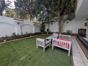 two white chairs and a table in a yard at A private room by the rooftop in Cairo