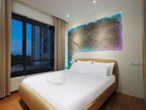 a bedroom with a large white bed with a window at Central Park Premium 4pax unit in Johor Bahru +29 photos