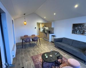 a living room with a couch and a table at Enkhuizer Strand Chalet Meereszauber Nr 304 in Enkhuizen +4 photos