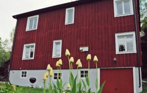a red barn with yellow flowers in front of it at MUSES BNB Bed & Breakfast in Bergvik