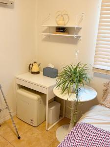 a bedroom with a desk and a table with a plant at Citrus Stay in Seoul