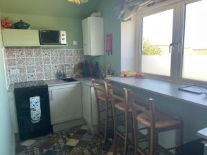 a kitchen with a counter and two chairs in it at old coastguards station in Wells next the Sea +13 photos