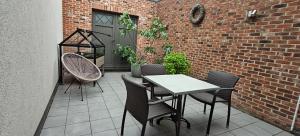 a patio with a table and chairs and a brick wall at holiday home Zonnestraal in Zonhoven