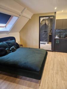 a bedroom with a large bed and a kitchen at B&B La Clé Lopik in Lopik