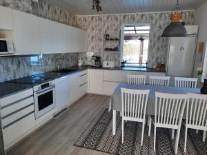 a kitchen with white cabinets and a table and chairs at Villa Tarvas by Hilla Villas in Rovaniemi