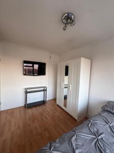 Un dormitorio con una cama y un televisor en la pared. en Jarman house, London, en Londres 1 foto más