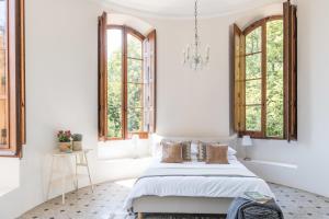 Majordoms - Castell de Villavecchia - 20 pax في سانت إلاري ساكالم: غرفة نوم بسرير مع نوافذ وثريا