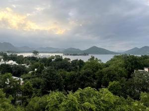a view of a lake with mountains in the distance at Casa Rio - Modern 3 BR near Fateh Sagar lake in Udaipur