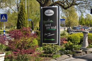 a sign for a hotel gunwell in a park at Hotel am Wall in Soest