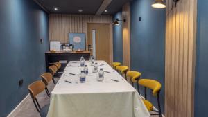 a long table in a room with yellow chairs at Plaza Hotel, Chorley, Sure Collection By BW in Chorley