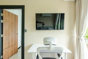 una mesa blanca y una silla en una habitación con espejo en Room 402 Rawai Beach Condo, en Nai Harn Beach