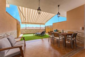 a living room with a table and chairs and a couch at Spacious Ocean View Family Townhouse in Puerto de Santiago