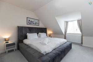 une chambre avec un grand lit avec des draps blancs dans l'établissement Oakwood Lodge, à South Bank