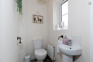 une salle de bains blanche avec toilettes et lavabo dans l'établissement Oakwood Lodge, à South Bank 28 autres photos