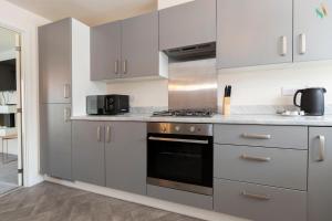 une cuisine avec des armoires blanches et un four à plaques de cuisson dans l'établissement Oakwood Lodge, à South Bank